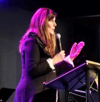 Attachment4 Woman speaking at a conference with a mic