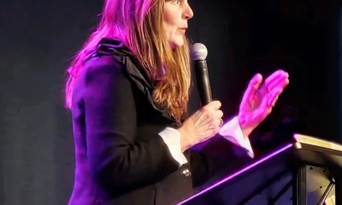 Woman speaking at a conference with a mic